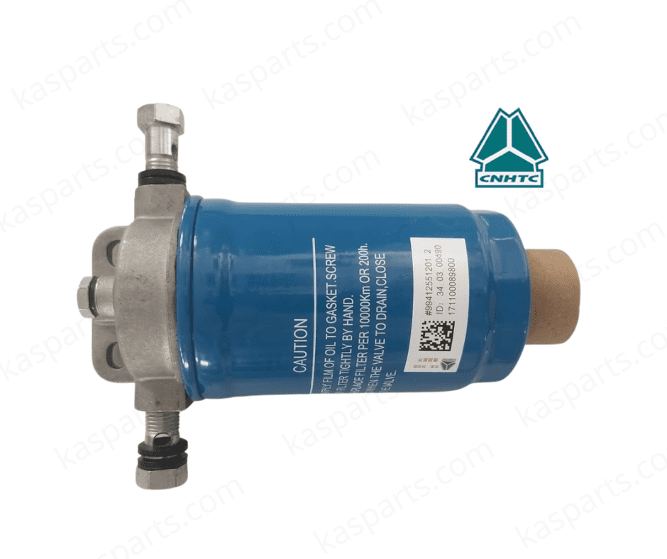 A professional studio photograph of a CNHTC Sinotruk fuel filter assembly (Filtre à gasoil), part number WG9412551201. The unit consists of a cylindrical blue filter canister mounted to a cast aluminum filter head with integrated inlet/outlet ports and hollow mounting bolts. A white technical label features a barcode, QR code, and "Caution" instructions in English. The image includes the teal CNHTC logo in the top right and a "kasparts.com" watermark throughout the white background.